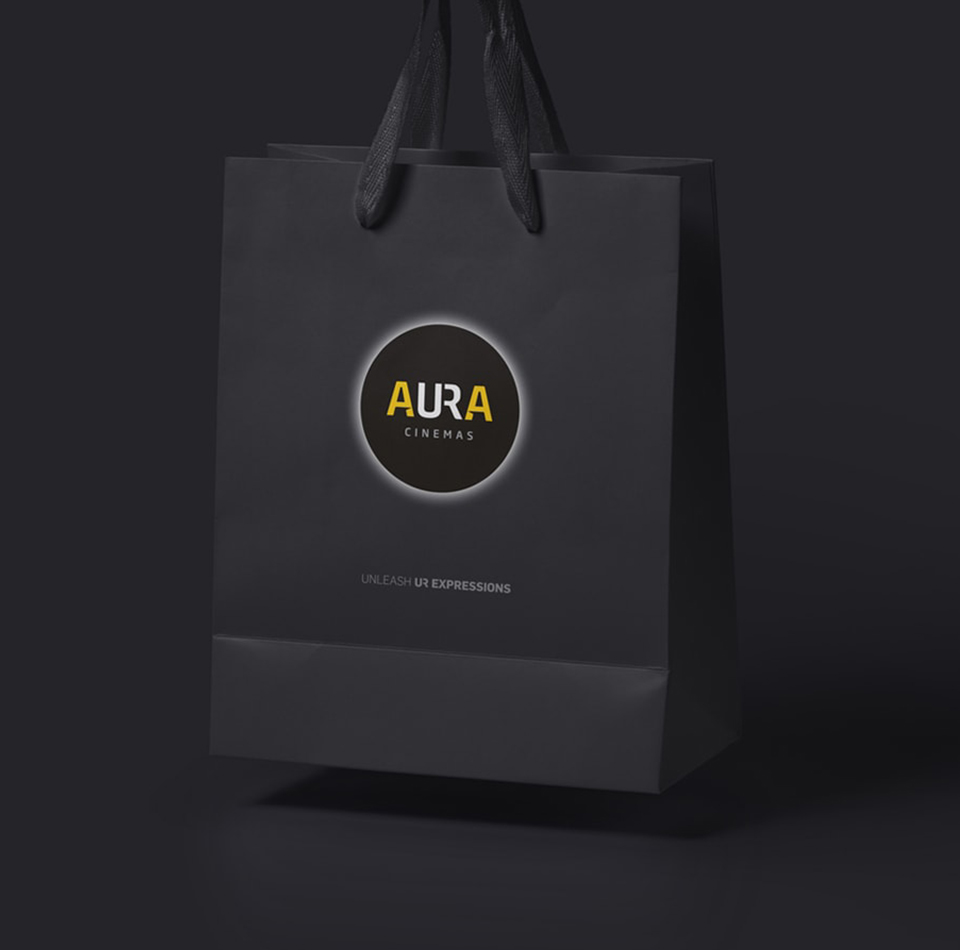 Branded merchandise: Aura Cinemas logo on a sleek black shopping bag, ideal for movie promotions and customer giveaways at the Bengaluru cinema.