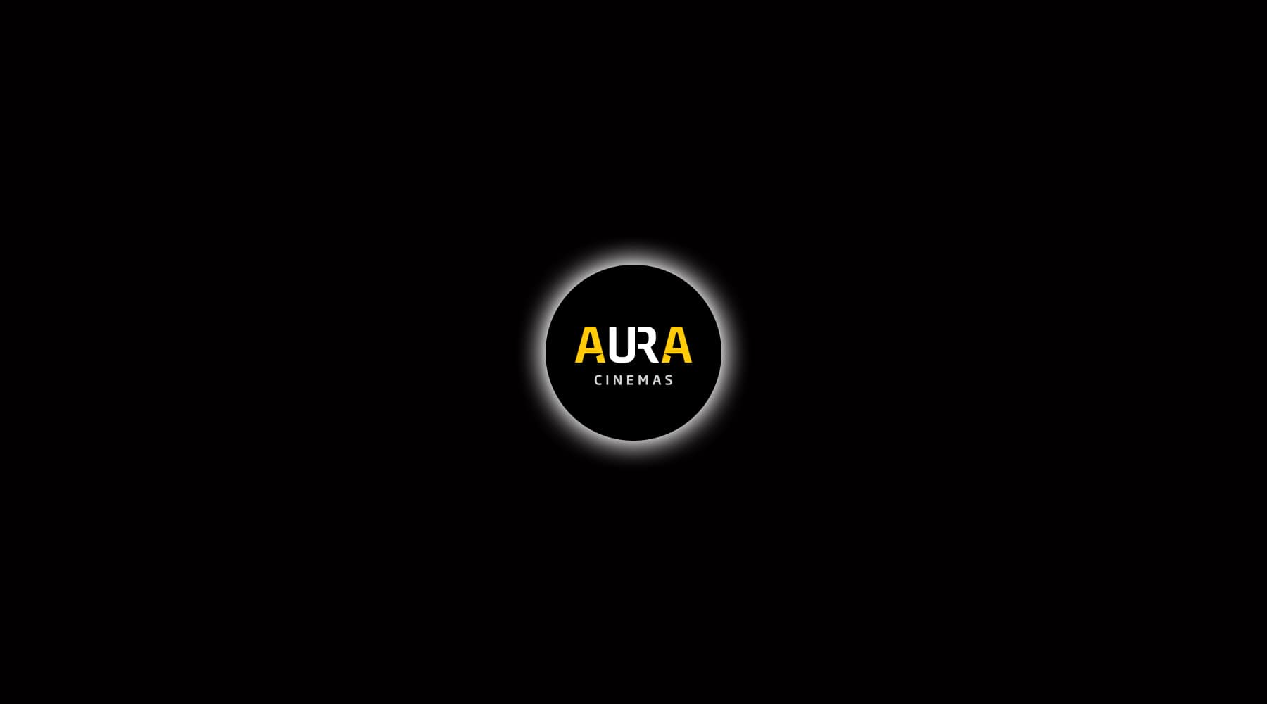 Official Aura Cinemas brand logo: yellow and white text inside a glowing circle on a dark background, signifying a premium cinema experience in Bengaluru.