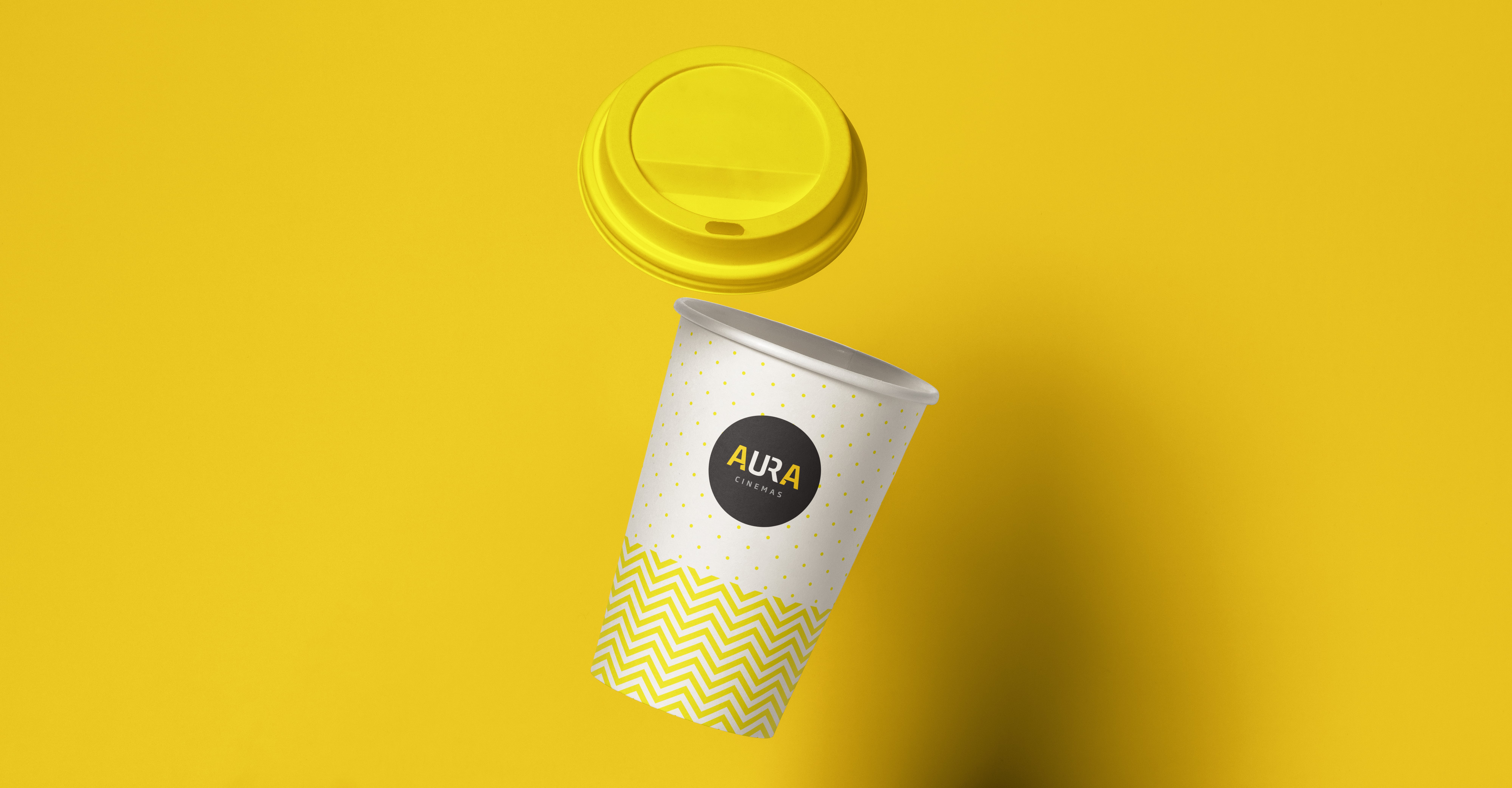 Aura Cinemas branded cup with yellow lid and zigzag pattern, offering a stylish beverage option for an enhanced cinema experience