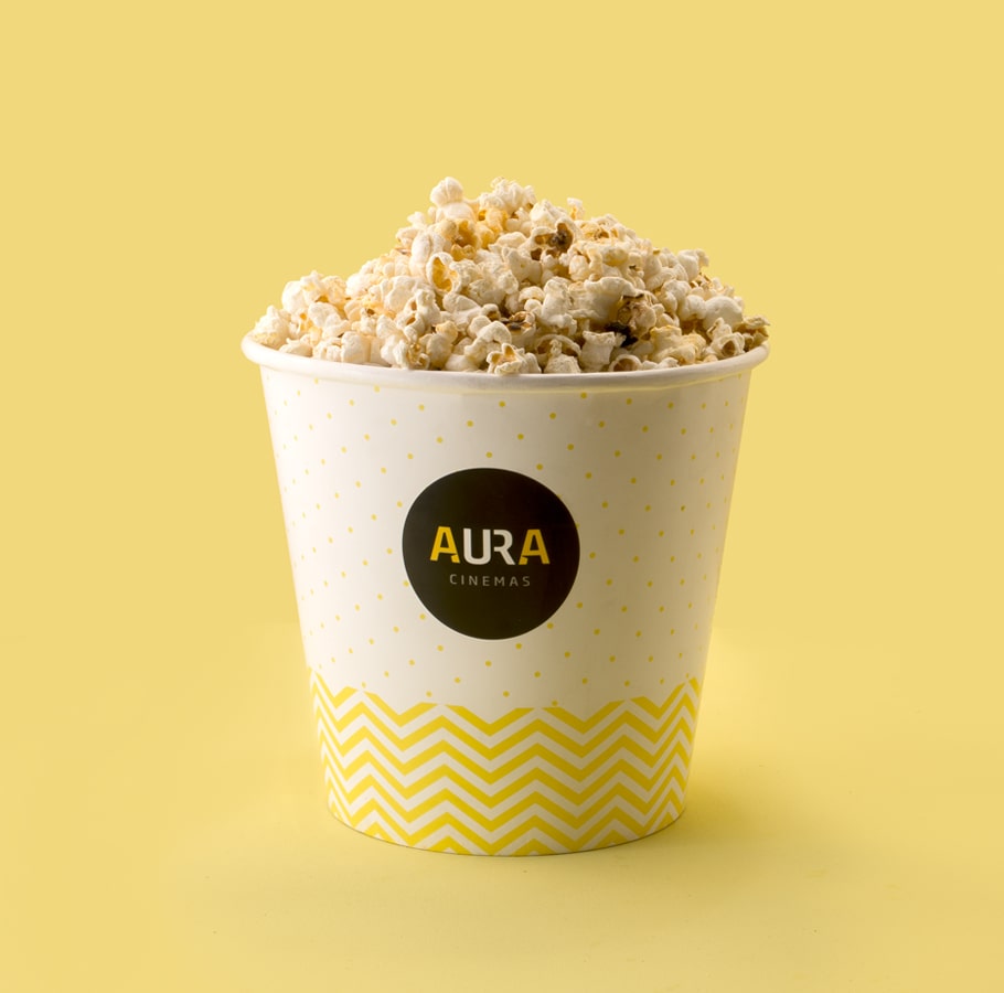 Aura Cinemas flavored popcorn in a yellow zigzag-patterned bucket on a tray, ideal for an enjoyable movie snack experience