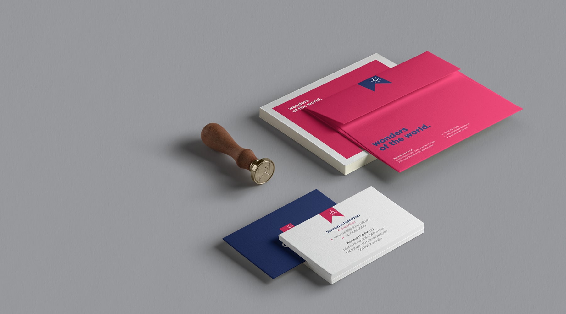 Modern Club W stationery set with business cards, envelopes, and wax seal stamp in vibrant pink and blue, showcasing professional branding and contact details