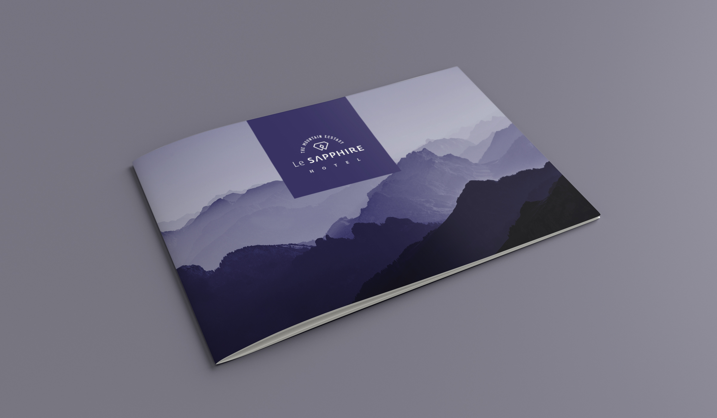 Le SAPPHIRE Hotel brochure cover displaying a purple and blue mountain landscape with the hotel logo on a grey background.