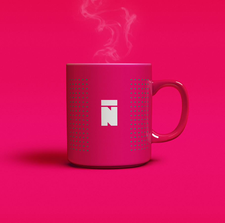 Nuetone branded pink mug with a white 'N' logo and green dotted pattern, steaming hot, representing the brand's stylish merchandise on the website