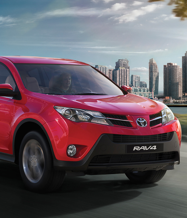 A vibrant red Toyota RAV4 SUV driving on a city street, 
                with a modern skyline in the background, representing the Neutone brand.