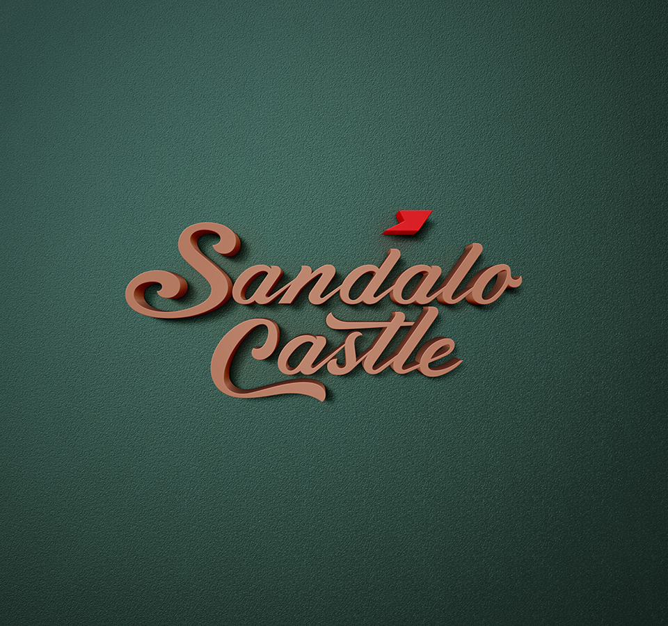A three-dimensional rendering of the Sandalo Castle logo, featuring a cursive-style font in a light brown or bronze color with a red flag accent. The logo has a drop shadow and is set against a dark, textured green background.