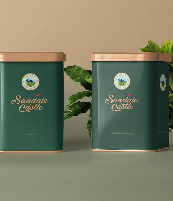 Two branded canisters for Sandalo Castle Resorts, 
                featuring a green and gold design with the resort's logo and a plant in the background, representing a premium feel.