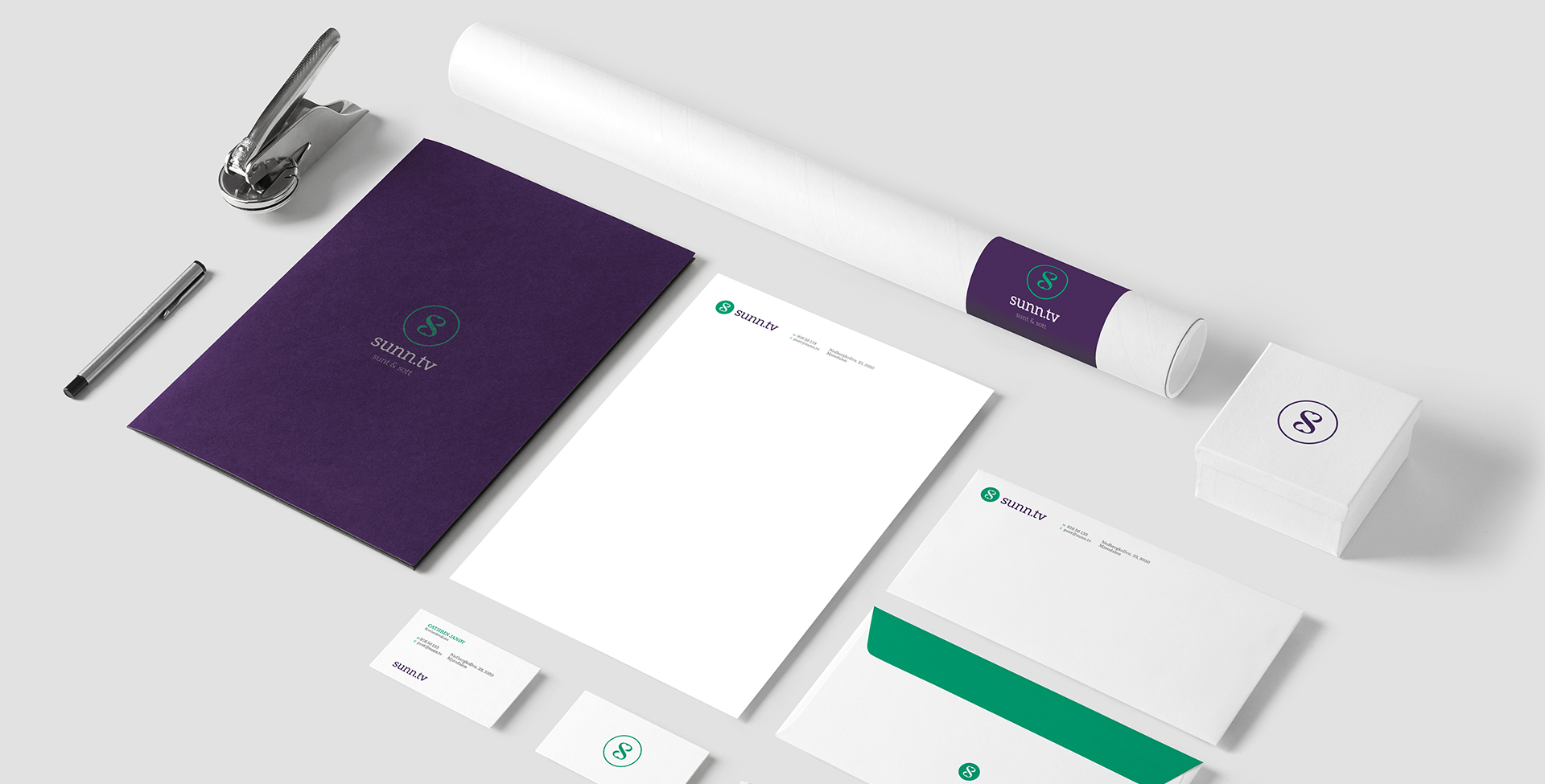 An aerial view of the sunn.tv brand's corporate identity materials, including a folder, letterhead, business cards, envelope, and a paper tube, all featuring the company's logo and color scheme.
