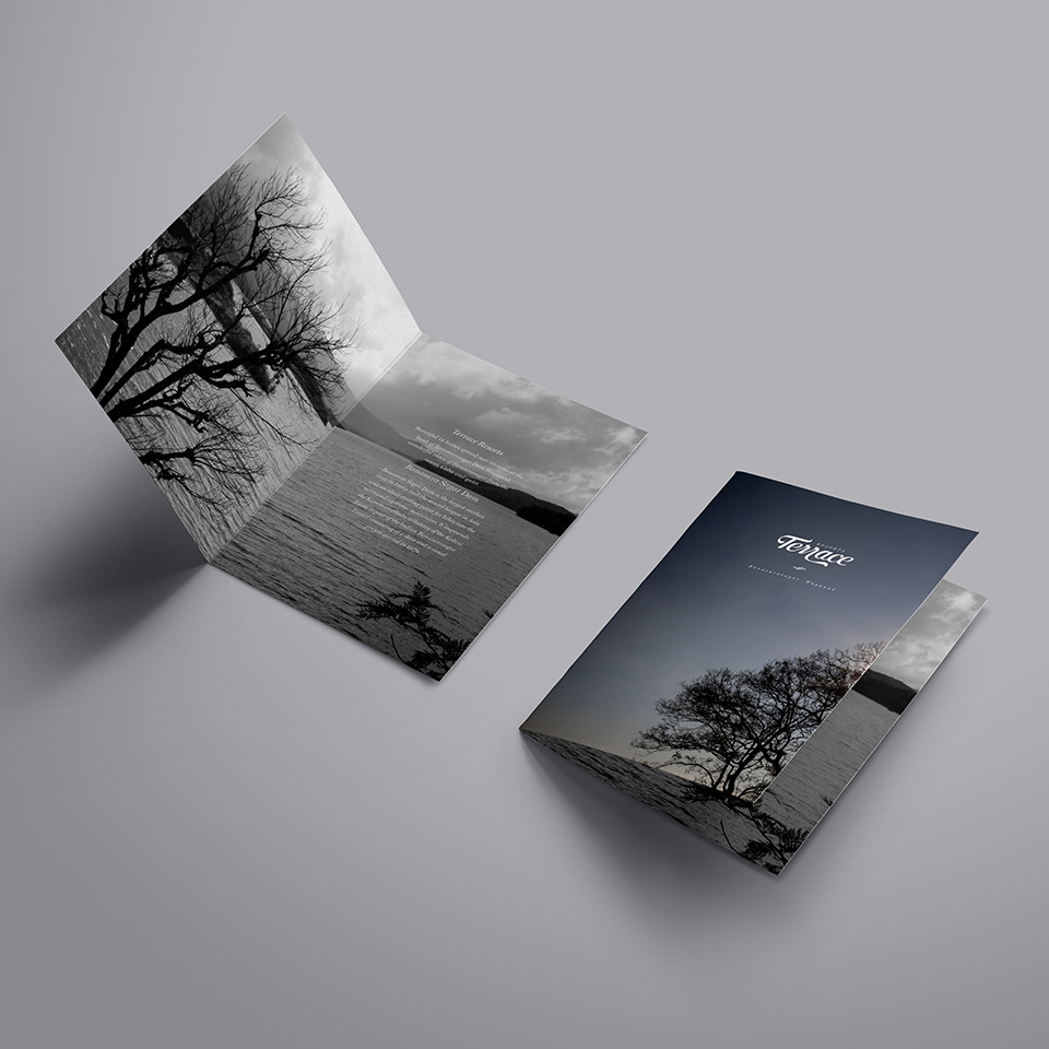 A collection of Terrace Resorts branding materials on a light blue background. The items include a presentation folder with a wavy pattern, a letterhead, a small notepad, business cards, and a white envelope with a light blue flap.